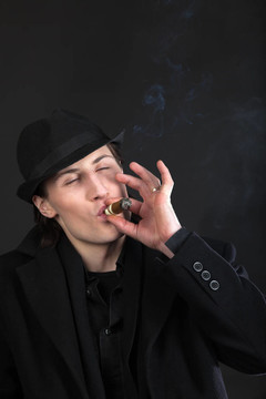戴黑帽子的男人和雪茄煙