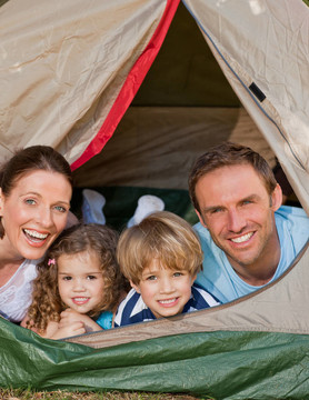 快乐的家庭在花园里野营