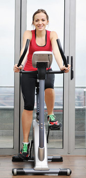 在健身俱樂部womanworkout在軌道上運行的機器