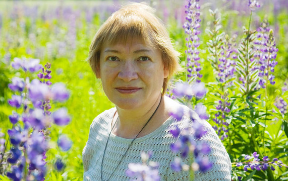 在紫色的野生羽扇豆植物的女人