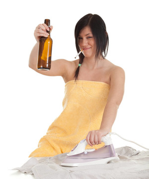 醉酒抽煙的年輕婦女熨燙衣服；家務(wù)活和留瓶啤酒