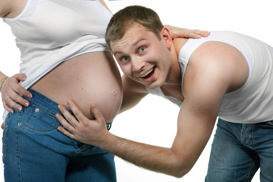 幸福的微笑男人與孕婦孤立的白色