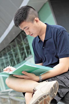 休閑亞洲商人在他的書(shū)上發(fā)短信。