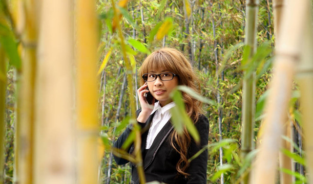 美麗的亞洲婦女在公園里使用智能手機(jī)
