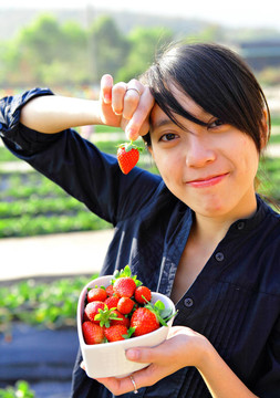 快乐的女人摘草莓