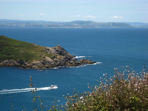 海岸上的花岗岩岩石岬；有一条船穿过大海