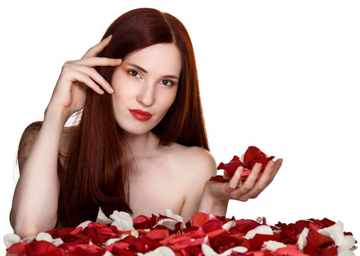 美麗的女人和白色背景上的玫瑰花瓣