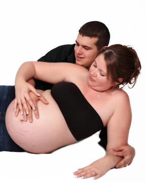 期待情侶一起欣賞孕婦懷肚子。白色隔離