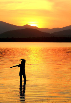 夕陽(yáng)下一個(gè)女孩在水中的輪廓