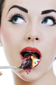 美麗的年輕女人吃甜蛋糕