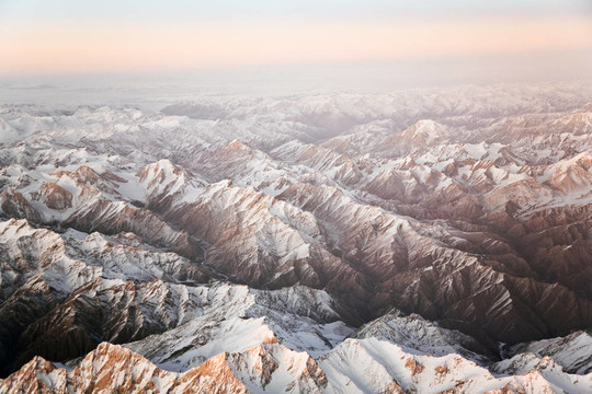 從飛機(jī)在塔什干山上美麗的景色；中國(guó)和Kirgistan；覆蓋著雪