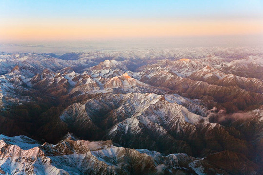 從飛機(jī)在塔什干山上美麗的景色；中國(guó)和Kirgistan；覆蓋著雪