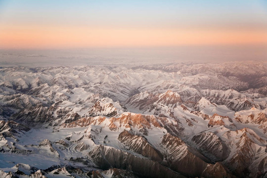從飛機(jī)在塔什干山上美麗的景色；中國(guó)和Kirgistan；覆蓋著雪