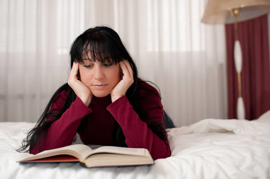 女孩在臥室里讀一本書