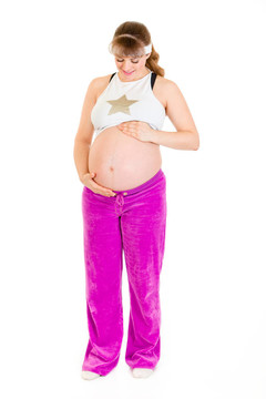 孕婦穿著運(yùn)動(dòng)服抱著她的肚子孤立在白色