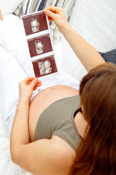 孕婦在家里放松沙發(fā)和尋找回聲。特寫。