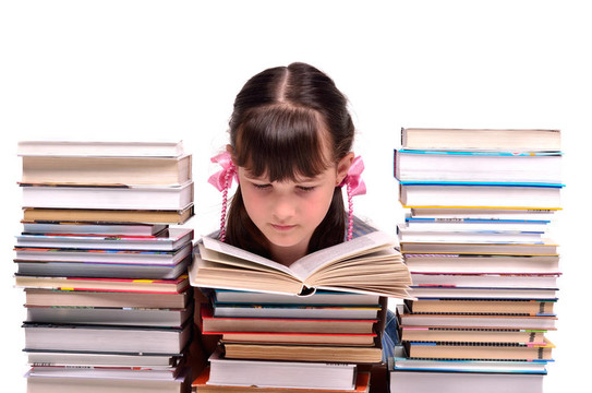 小女孩讀著一本書坐在成堆的書中