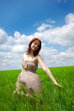 年輕漂亮的女孩在綠色的田野