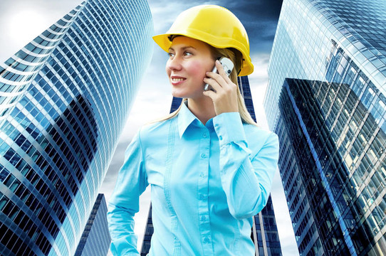 站在建筑物背景上的年輕建筑師女士戴著防護(hù)頭盔