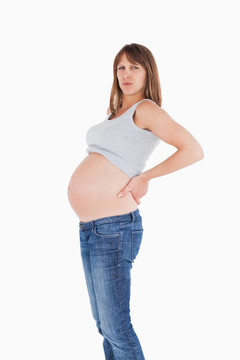 美麗的孕婦抱著她站著