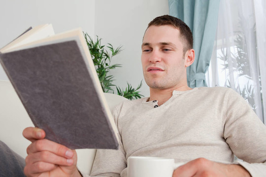 男人一邊喝茶一邊看書