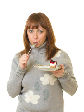 年輕的女人吃美味的蛋糕