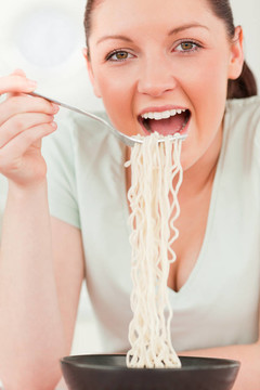 迷人的女人一邊吃面食一邊擺姿勢