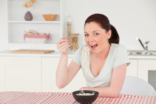 美女一邊吃碗面食一邊擺姿勢(shì)