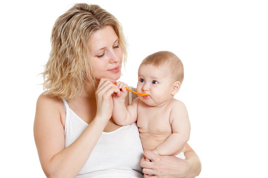 母親用勺子喂她的嬰兒