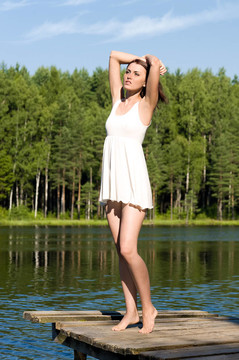 美丽的女人站在湖中。夏天的时间