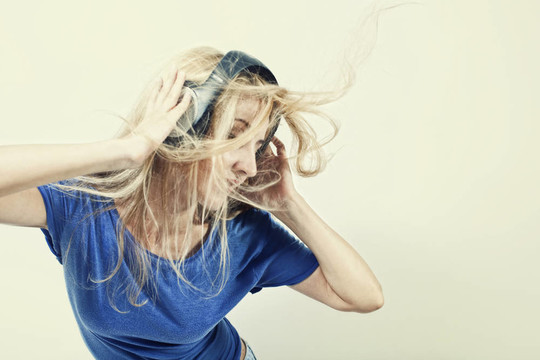 年輕的女人用耳機唱歌