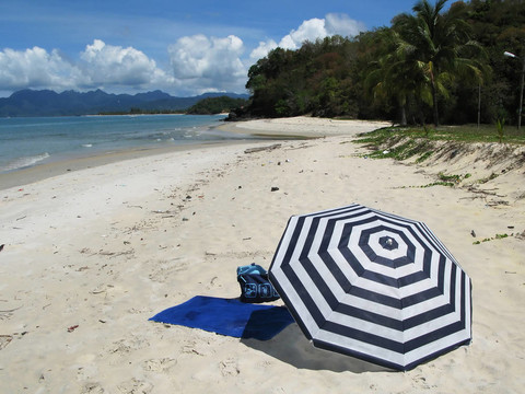 條紋傘上的一個(gè)僻靜的海灘Langkawi島；馬來西亞