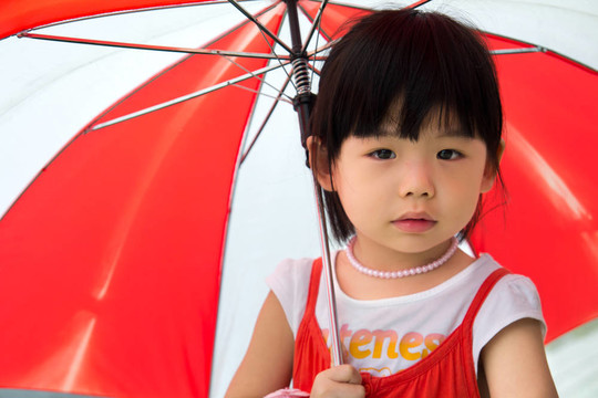 帶紅傘的亞洲小孩
