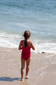 走进海边的小女孩在沙滩上冲浪