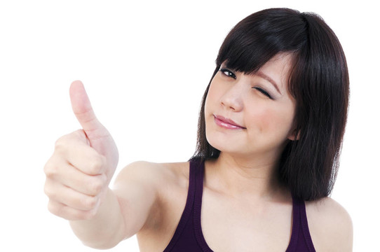 可愛的年輕女性眨眼給豎起大拇指的手勢(shì)