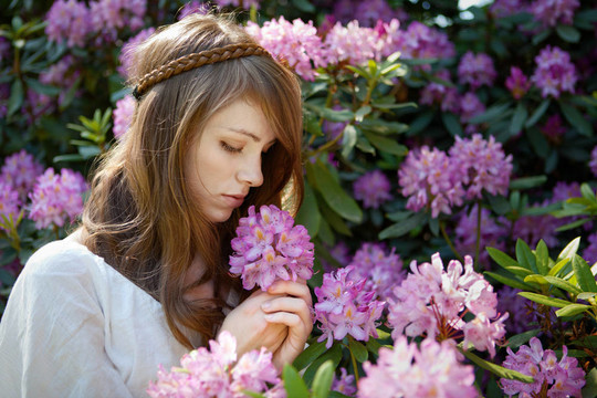 一個(gè)年輕的女士一個(gè)杜鵑花的香味喜歡
