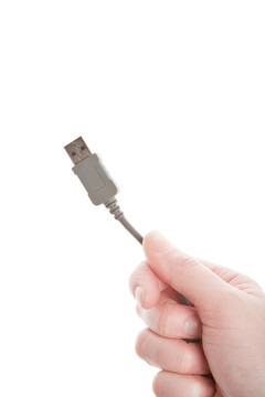 手上拿著灰色的USB電纜