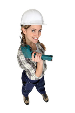 女建筑工人拿著鉆。