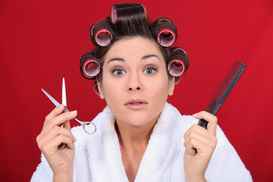 女人的頭發(fā)卷起來(lái)拿著剪刀和梳子