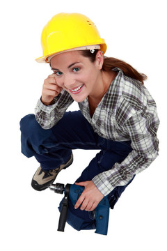帶鉆孔的女建筑工人。