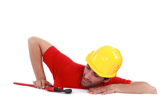 一個建筑工人在看他的扳手。