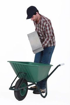瓦工把混凝土塊在手推車