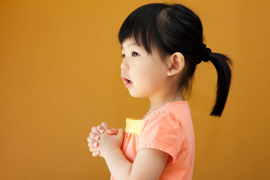 亞洲小女孩正在祈禱