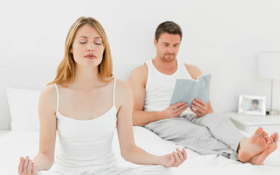 女人練習瑜伽，而丈夫在讀書