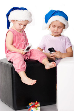 兩個孩子在Santa的帽子上發(fā)送問候語的手機