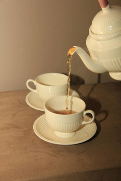 在經(jīng)典的白色茶杯倒茶