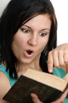 一個年輕的女人在一本書上看書