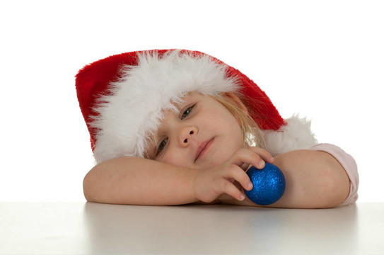 疲憊的圣誕女孩在紅色Santa帽子與玻璃球