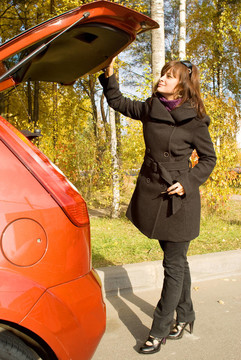 女孩關(guān)上紅車的行李地點(diǎn)