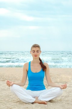 美麗女子在海灘上練習(xí)瑜伽